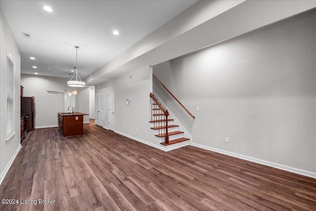 unfurnished living room with sink and dark hardwood / wood-style floors