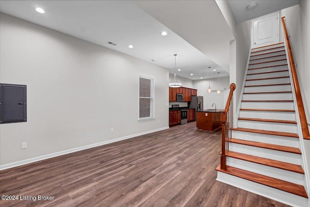 living room with electric panel, sink, and hardwood / wood-style flooring