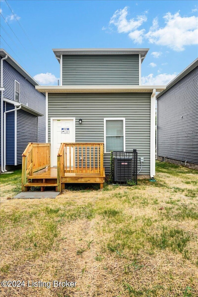 rear view of property with a wooden deck and a yard