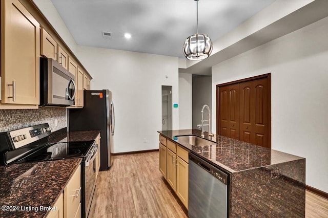 kitchen with backsplash, light hardwood / wood-style flooring, appliances with stainless steel finishes, sink, and pendant lighting