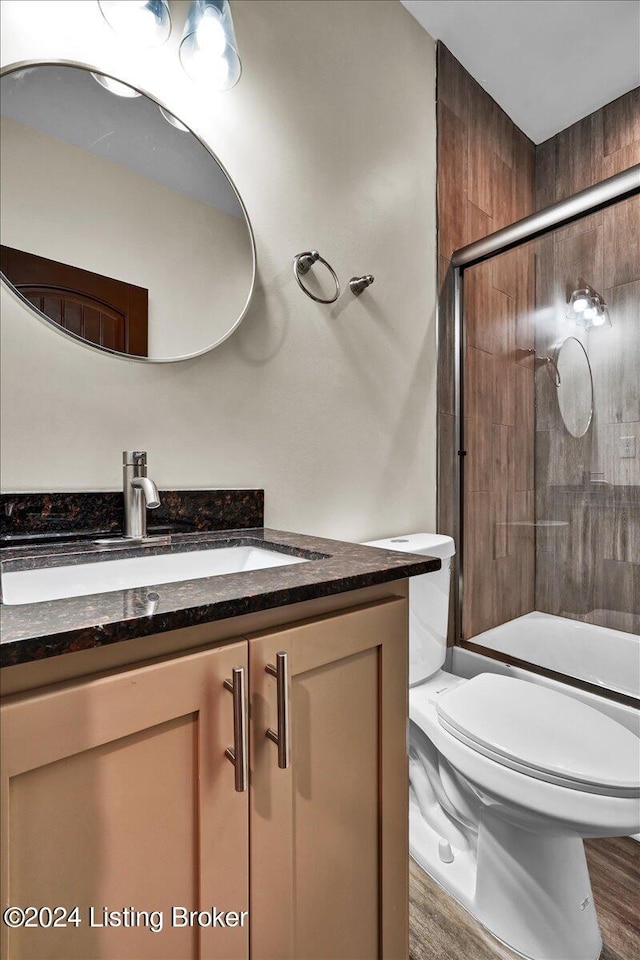 bathroom with a shower with door, vanity, toilet, and hardwood / wood-style flooring