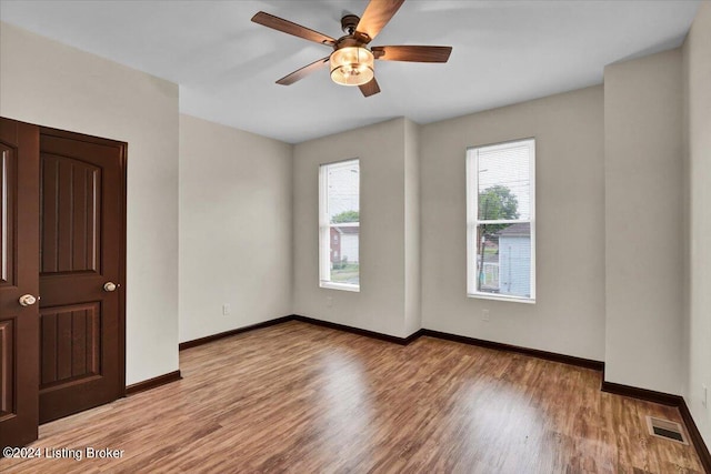 spare room featuring plenty of natural light, light hardwood / wood-style flooring, and ceiling fan