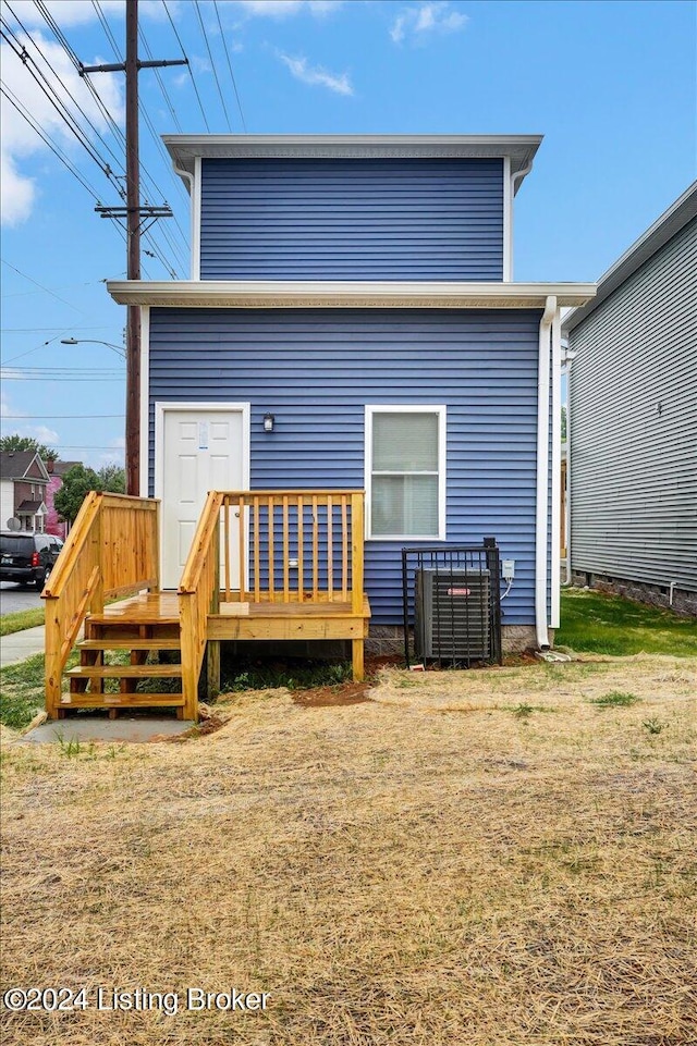 rear view of property with a yard and a deck