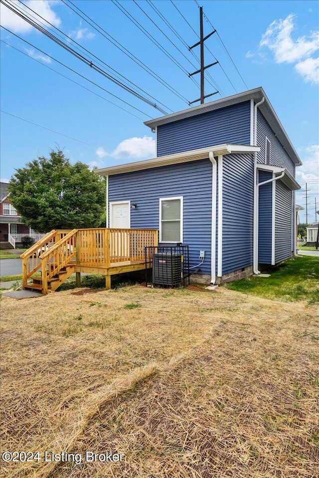 rear view of house featuring a yard and a deck