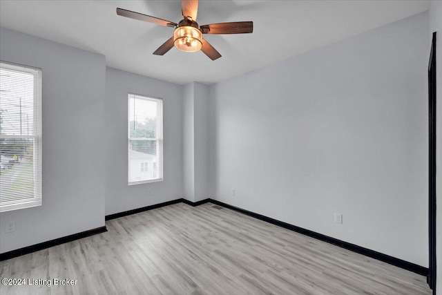 empty room with ceiling fan and light hardwood / wood-style floors