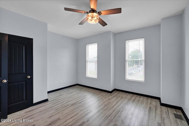 unfurnished room with a healthy amount of sunlight, ceiling fan, and light hardwood / wood-style floors