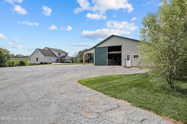 view of outbuilding with a garage, a lawn, and a carport