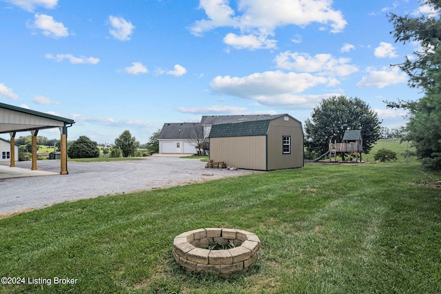 view of yard featuring a playground and a storage unit