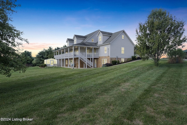 property exterior at dusk featuring a wooden deck and a lawn