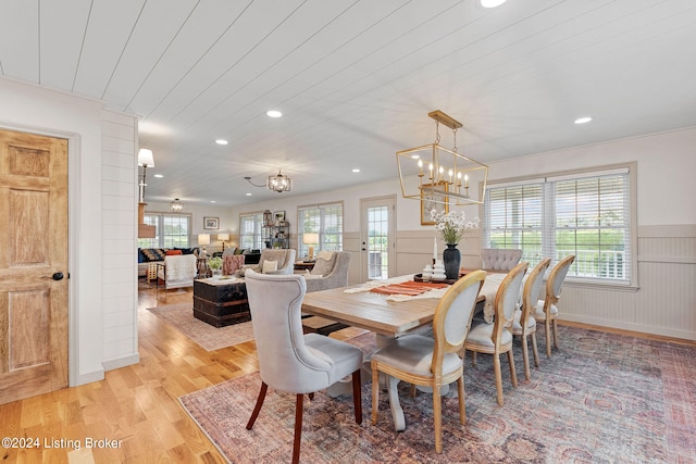 dining space featuring a healthy amount of sunlight, a chandelier, and light hardwood / wood-style flooring