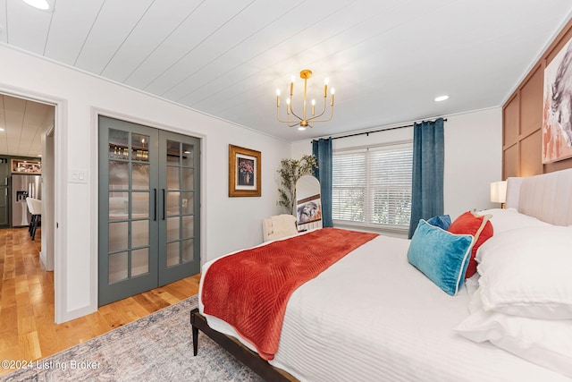 bedroom featuring stainless steel fridge, light hardwood / wood-style flooring, french doors, and a notable chandelier