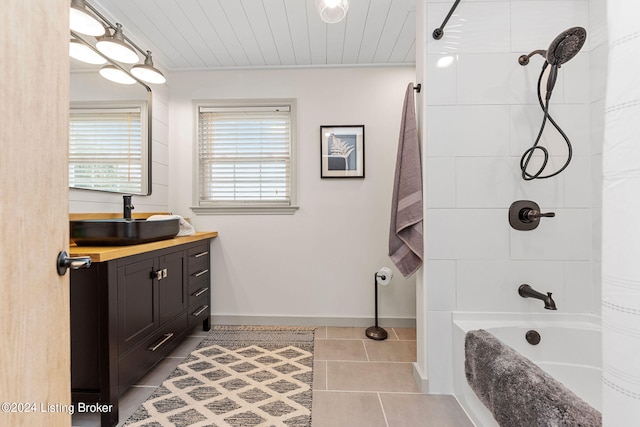 bathroom featuring tile patterned floors, tiled shower / bath combo, and vanity