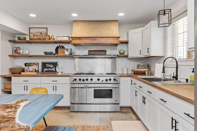 kitchen with white cabinetry, backsplash, double oven range, hanging light fixtures, and custom range hood