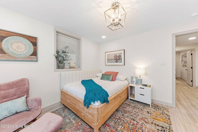 bedroom featuring a notable chandelier and light wood-type flooring