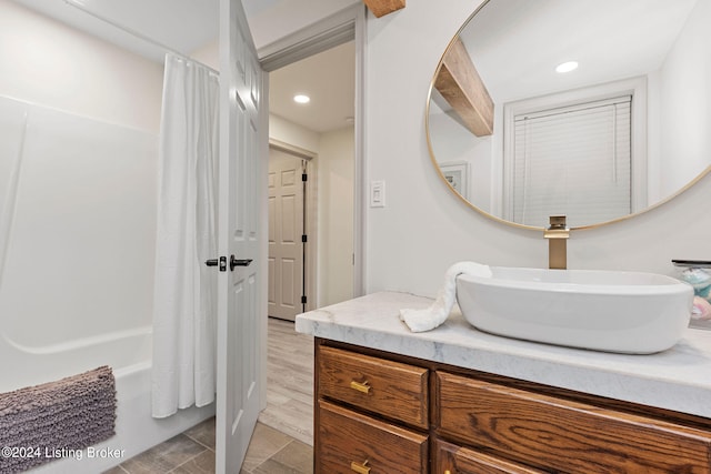 bathroom featuring hardwood / wood-style flooring, shower / tub combo, and vanity