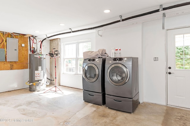 washroom with gas water heater, washer and dryer, and electric panel