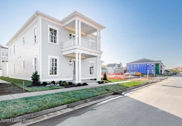 neoclassical home featuring a balcony