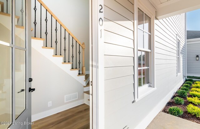 staircase featuring crown molding and hardwood / wood-style floors