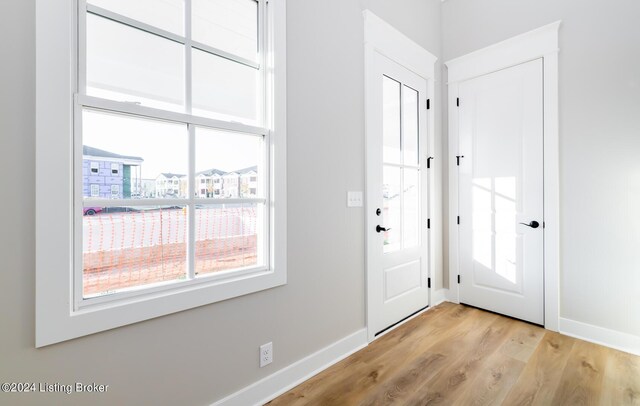 entryway with light wood-style flooring and baseboards