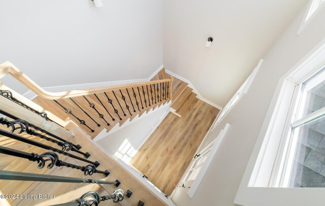 stairs with a towering ceiling and hardwood / wood-style floors