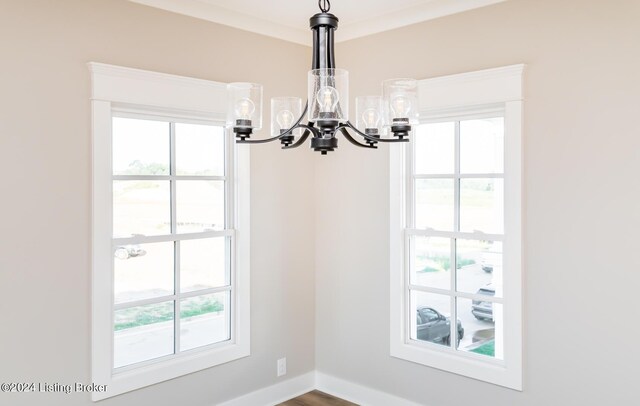 interior space featuring crown molding, plenty of natural light, and a notable chandelier