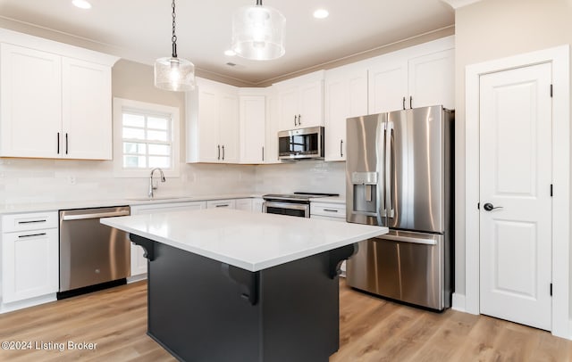 kitchen featuring light wood-type flooring, backsplash, stainless steel appliances, and sink