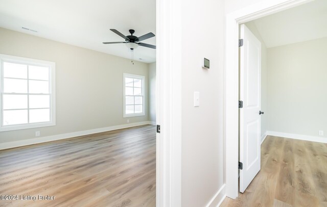 spare room featuring visible vents, ceiling fan, light wood-type flooring, and baseboards