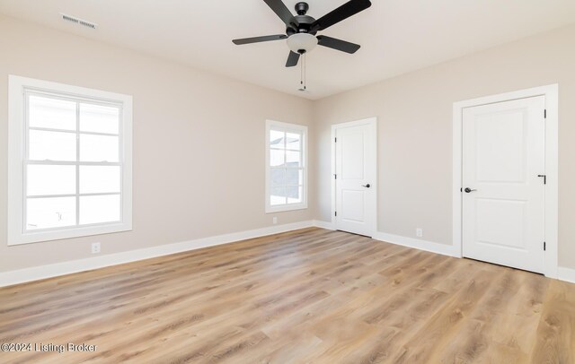 unfurnished bedroom featuring light wood-style flooring, baseboards, and visible vents