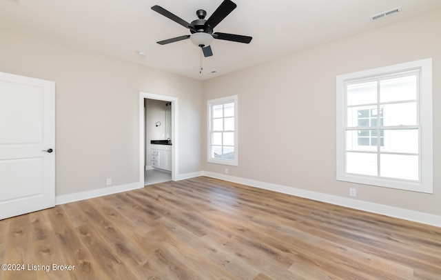 unfurnished bedroom featuring ceiling fan, hardwood / wood-style floors, and ensuite bathroom