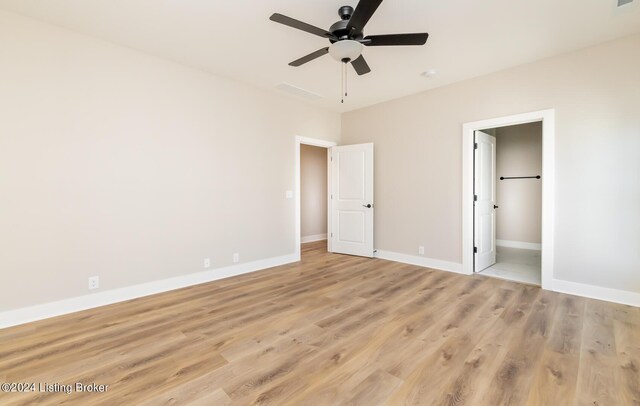 unfurnished bedroom featuring light wood-type flooring, connected bathroom, and ceiling fan