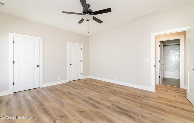 unfurnished bedroom with ceiling fan, light hardwood / wood-style floors, and ensuite bathroom