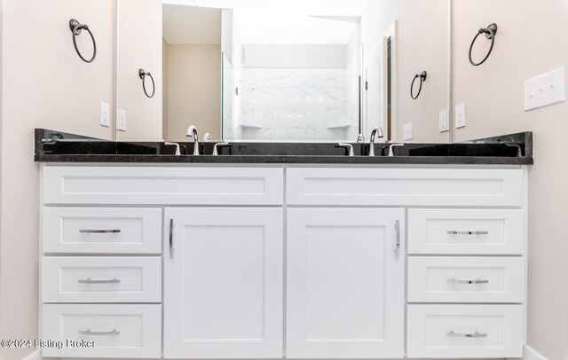 bathroom featuring a sink, walk in shower, and double vanity