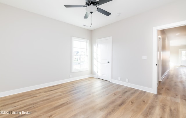 unfurnished room with a healthy amount of sunlight, ceiling fan, and light hardwood / wood-style flooring