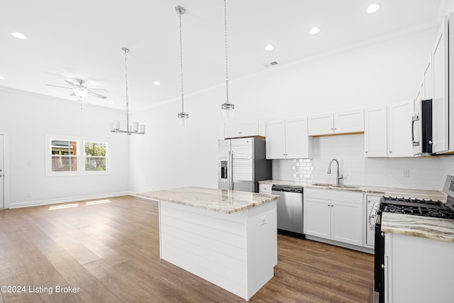 kitchen with a kitchen island, stainless steel appliances, dark hardwood / wood-style floors, and crown molding