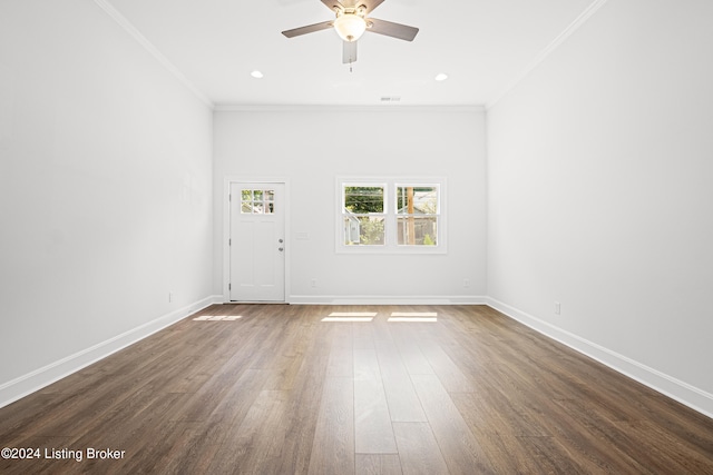 spare room featuring dark wood-type flooring, ceiling fan, and ornamental molding