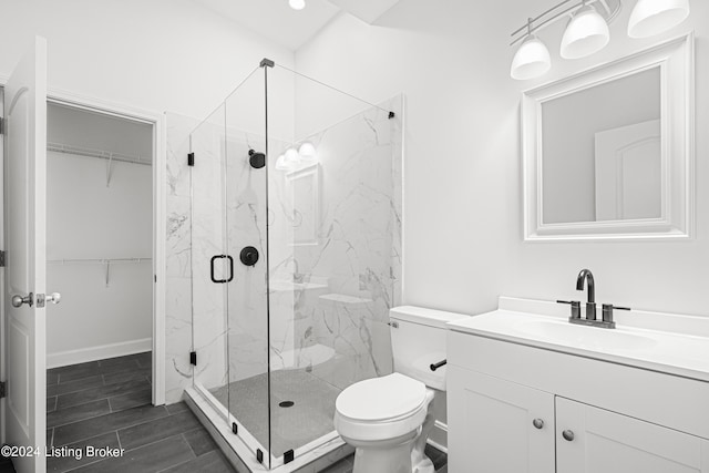 bathroom with vanity, toilet, and a shower with door