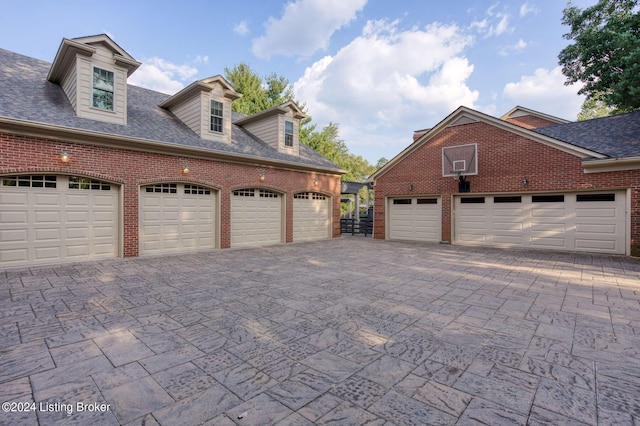 view of property exterior featuring a garage, brick siding, and roof with shingles