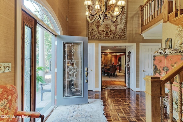 foyer with stairway, a notable chandelier, a towering ceiling, and baseboards