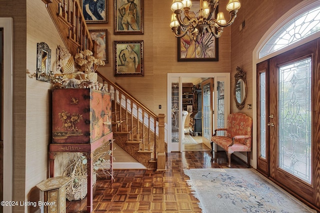 entryway featuring wallpapered walls, stairway, baseboards, and an inviting chandelier