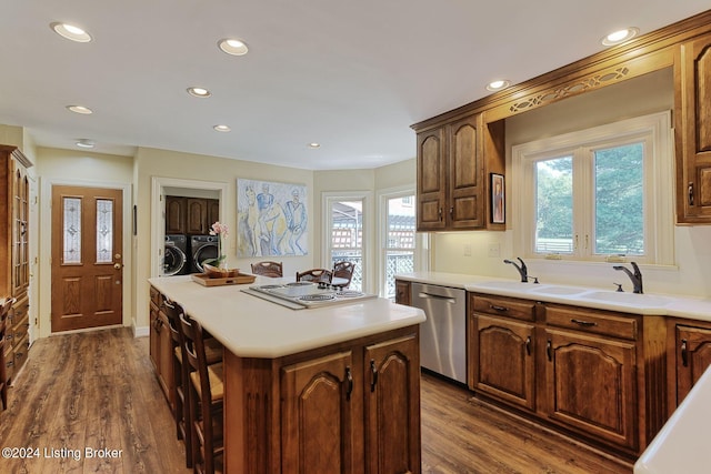 kitchen featuring a sink, a healthy amount of sunlight, white electric cooktop, separate washer and dryer, and stainless steel dishwasher