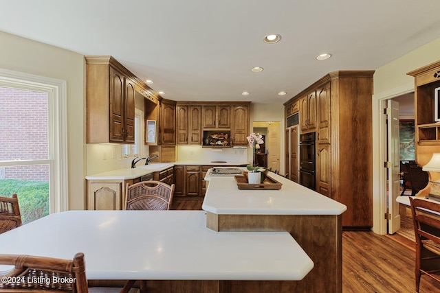 kitchen with light countertops, plenty of natural light, a center island, and dark wood finished floors