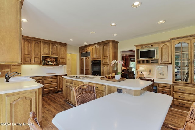 kitchen with dark wood-type flooring, a center island, light countertops, and a sink