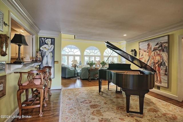 living area with ornamental molding, baseboards, and wood finished floors