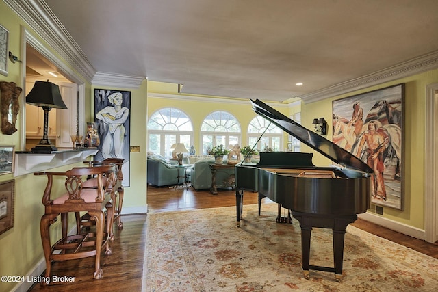 living area featuring baseboards, wood finished floors, and ornamental molding