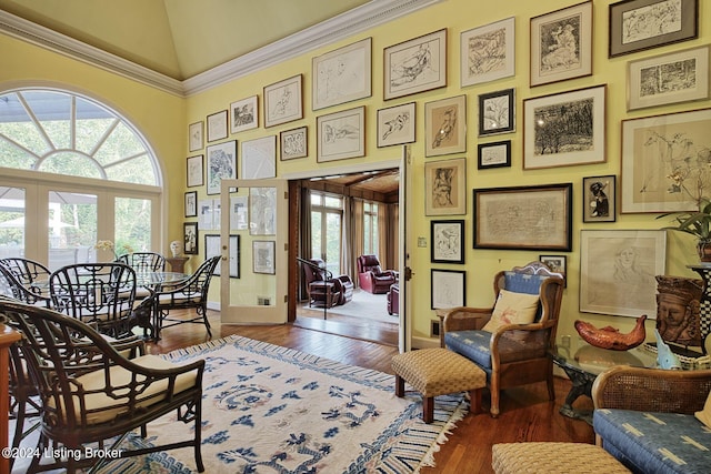 sitting room featuring high vaulted ceiling, baseboards, and wood finished floors