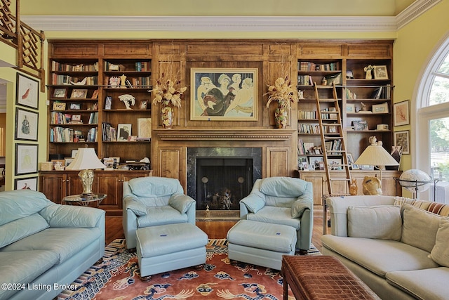 living room with wood finished floors, ornamental molding, and a premium fireplace