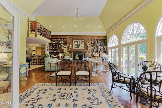 interior space with high vaulted ceiling, ceiling fan, wood finished floors, and crown molding