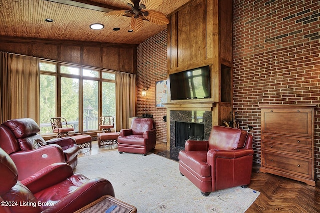 living room featuring wooden ceiling, a high ceiling, brick wall, ceiling fan, and a fireplace