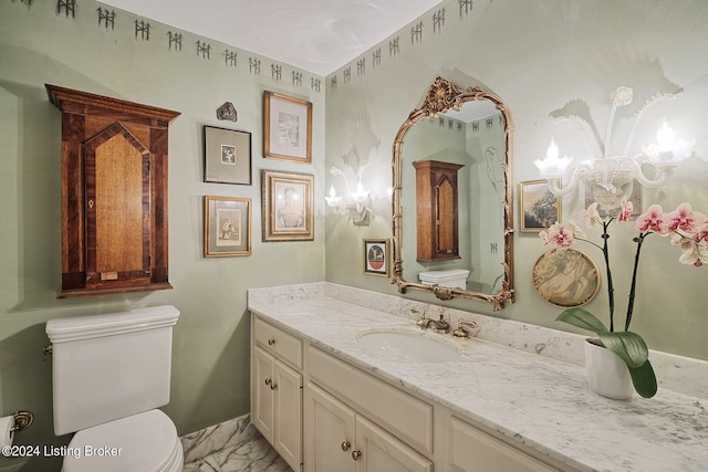 bathroom featuring marble finish floor, a notable chandelier, toilet, and vanity