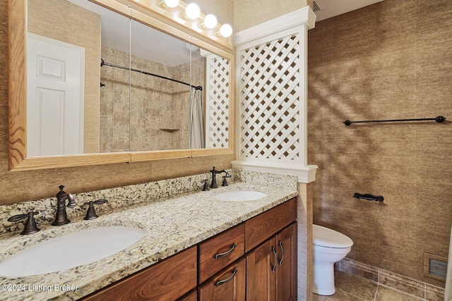 bathroom with visible vents, a sink, toilet, and double vanity